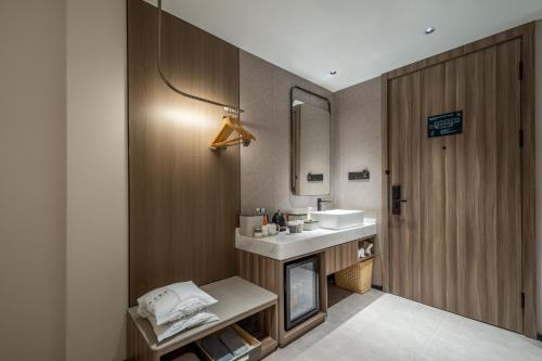 a bathroom with a sink and a mirror at Atour Hotel Anji Longshan in Anji
