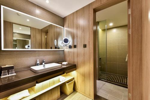 a bathroom with a sink and a shower at Atour Hotel Tianjin Binhai 1st Street in Binhai