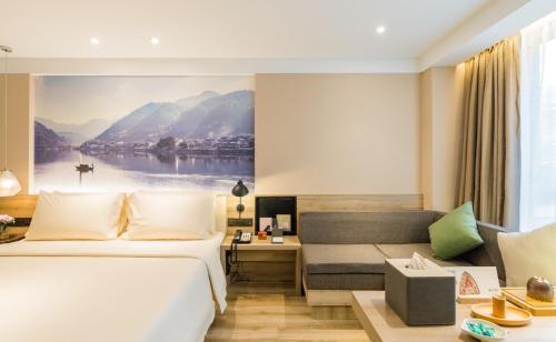 pokój hotelowy z łóżkiem i kanapą w obiekcie Atour Hotel Hangzhou West Lake Cultural Plaza Shangtang Road w mieście Hangzhou