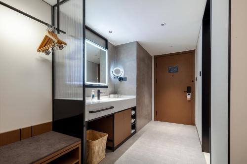 ein Bad mit einem Waschbecken und einem Spiegel in der Unterkunft Atour X Hotel Xiamen SM Plaza District Government in Xiamen