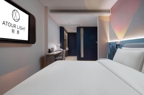 a bedroom with a large bed and a tv at Atour Light Hotel Changsha IFC Huangxing Road Pedestrian Street in Changsha