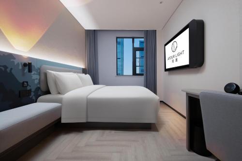 a hotel room with a bed and a flat screen tv at Atour Light Hotel Changsha IFC Huangxing Road Pedestrian Street in Changsha