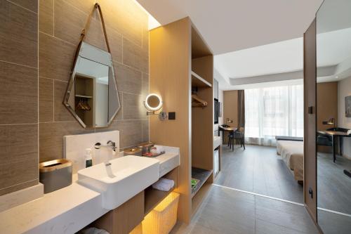 a bathroom with a sink and a mirror at Atour S Hotel Xinghai Square in Dalian