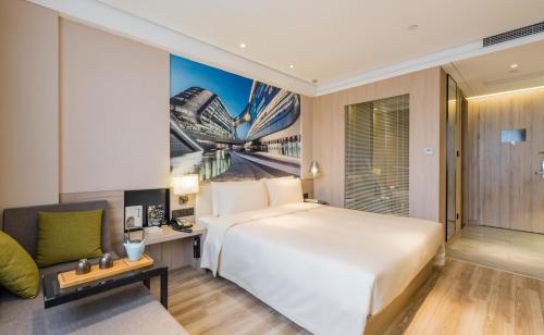 a hotel room with a large bed and a couch at Atour Hotel Shanghai Hongqiao National Exhibition Center Wuzhong Road in Shanghai