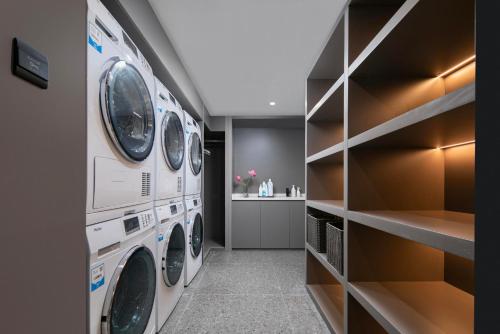 a laundry room with three washer and dryers at Atour Light Hotel Wuhan Jiangtan Jianghan Road Pedestrian Street in Wuhan