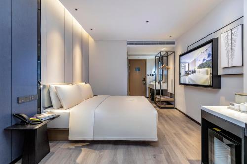 a bedroom with a large white bed and a bathroom at Atour Hotel Quanzhou Hongchang Baozhou Road in Quanzhou