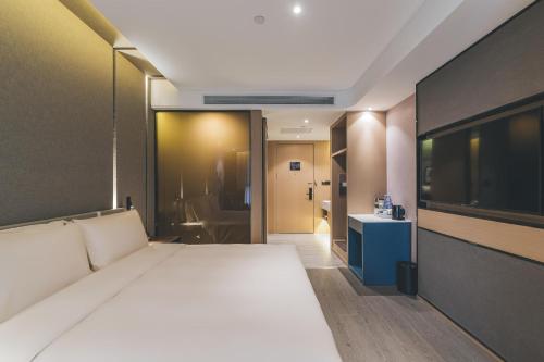 a bedroom with a large bed and a bathroom at Atour Hotel Lanzhou Dongfanghong Plaza in Lanzhou