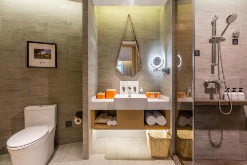 y baño con aseo, lavabo y ducha. en Atour Hotel Changzhou Wujin Science and Education City en Changzhou