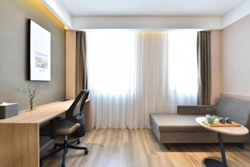 a room with a desk and a chair and a couch at Atour Hotel Beijing Yizhuang Mobile Silicon Valley in Daxing