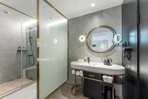 a bathroom with a sink and a shower and a mirror at Atour Light Hotel Shanghai Xujiahui Jiaotong University in Shanghai