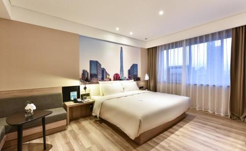 a hotel room with a large bed and a window at Atour Hotel Tianjin Binhai 1st Street in Binhai