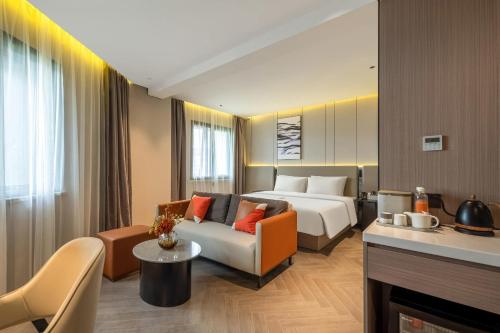 um quarto de hotel com uma cama e um sofá em Atour Hotel Shanghai Wujiaochang West Yingao Road Station em Xangai