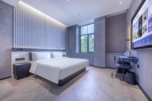 1 dormitorio con 1 cama blanca grande y escritorio en Atour Light Hotel Fuzhou Sanfang Qixiang en Fuzhou