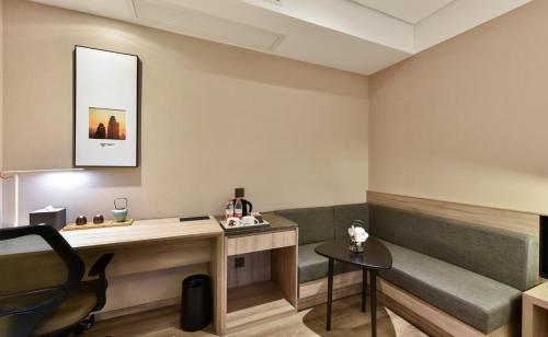a room with a desk and a bench and a table at Atour Hotel Tianjin Binhai 1st Street in Binhai