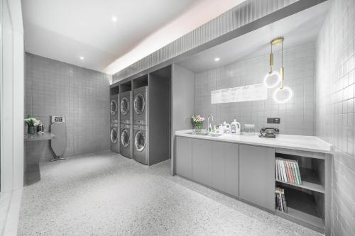 a laundry room with a sink and washing machines at Atour Light Hotel Shenzhen Nanshan Nanyouxi Station in Shenzhen