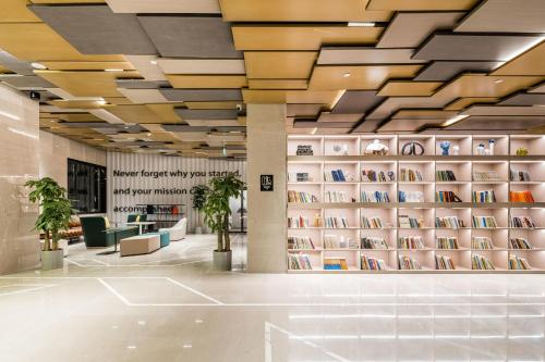 a library with a wall of books at Atour S Hotel Beijing Shangdi Qinghe High Speed Railway Station in Beijing