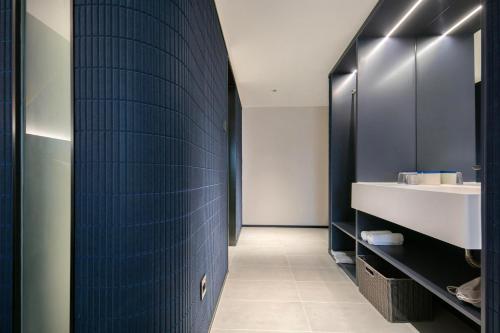 baño con pared de azulejos azules y lavamanos en Atour Light Hotel Wuhan Jiangtan Jianghan Road Pedestrian Street en Wuhan