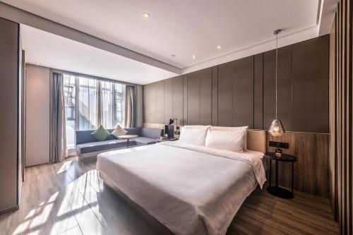 a bedroom with a large bed and a couch at Atour Hotel Shenzhen Nanshan Coast City in Shenzhen