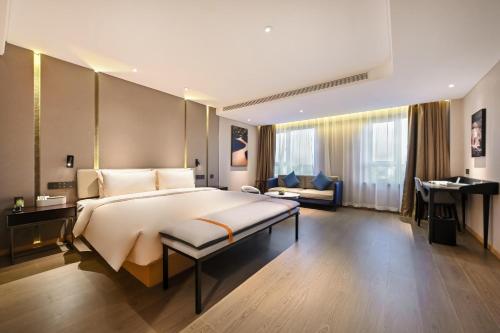 a large bedroom with a large bed and a desk at Atour Hotel Shenyang Nanta Wenhua Road in Shenyang