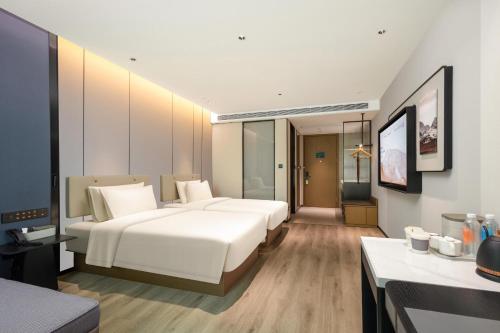 a hotel room with two beds and a television at Atour Hotel Quanzhou Jinjiang Sunshine Plaza in Jinjiang