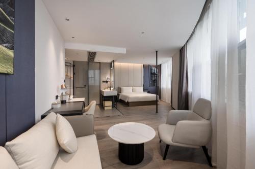 a living room with a couch and a table at Atour Hotel Xiamen North Station Jiageng Stadium in Xiamen