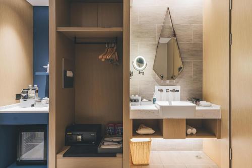 y baño con lavabo y espejo. en Atour Hotel Shanghai Xianxia, en Shanghái