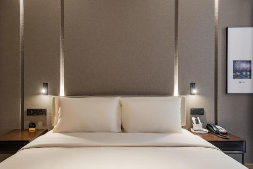 Ένα ή περισσότερα κρεβάτια σε δωμάτιο στο Atour Hotel Ningbo Yinzhou Impression City