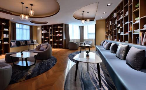 a living room with a couch and chairs and tables at Atour Hotel Dalian Zhongshan Square in Dalian