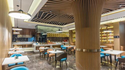 a restaurant with tables and chairs and a bar at Atour Hotel Kunming Cuihu in Kunming
