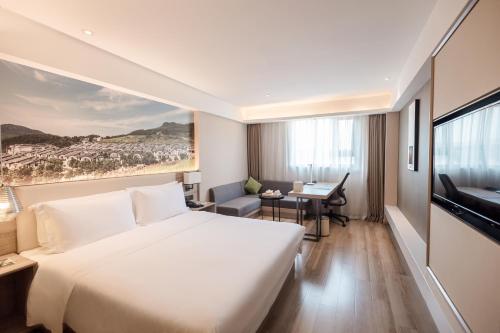 a hotel room with a large bed and a desk at Atour Hotel Chongqing Shapingba High Speed Railway Station Sanxia Plaza in Chongqing