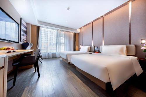 a hotel room with two beds and a desk at Atour Hotel Shenzhen Nanshan Xili Station in Shenzhen