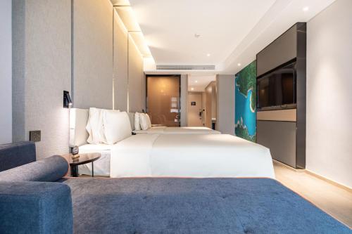 Pokój hotelowy z dużym łóżkiem i kanapą w obiekcie Atour Hotel Yichun Administrative Center w mieście Yichun