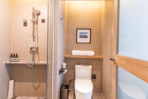 a bathroom with a toilet and a shower at Atour Hotel Xiamen Jimei University in Xiamen