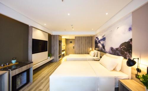 a hotel room with two beds and a flat screen tv at Atour Hotel Shenyang Olympic Yingpan Street in Shenyang