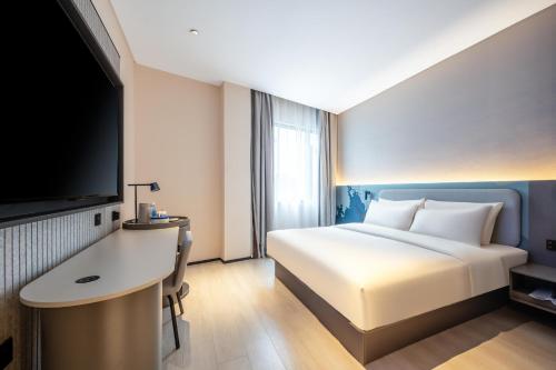 a hotel room with a bed and a flat screen tv at Atour Light Hotel Guangzhou Panyu Hanxi Changlong in Guangzhou