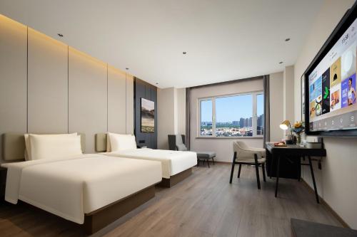 天津的住宿－天津中北海泰产业园亚朵酒店，酒店客房设有两张床和一台平面电视。