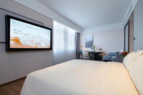a hotel room with a large bed and a flat screen tv at Atour Hotel Shenyang Zhongshan Plaza in Shenyang