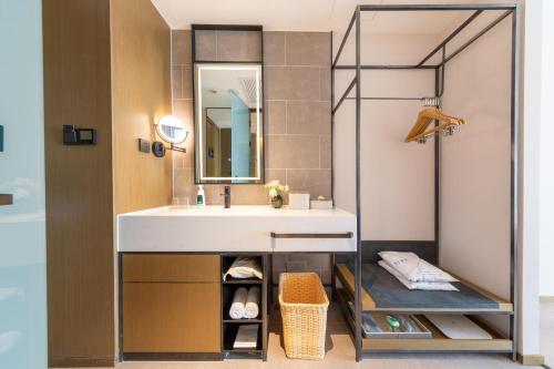 W łazience znajduje się umywalka i lustro. w obiekcie Atour Hotel Beijing Capital Airport New International Exhibition Center w Pekinie