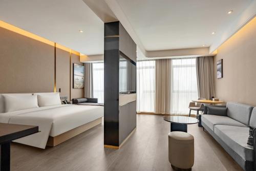 a hotel room with a bed and a couch at Atour S Hotel Xining Haihu New District SDIC Plaza in Xining