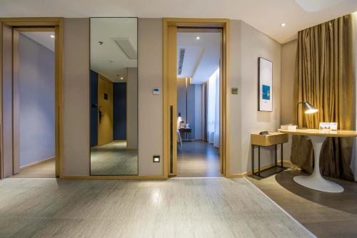 a hallway with a glass door and a table at Atour Hotel Shenzhen Nanshan Shekou in Shenzhen