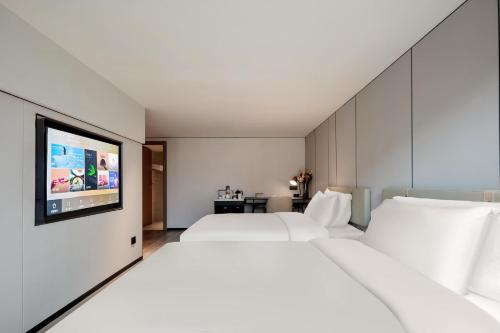 a hotel room with two beds and a flat screen tv at Atour X Hotel Xiamen SM Plaza District Government in Xiamen