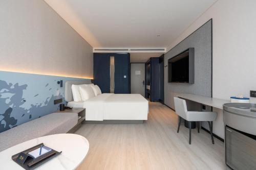 a hotel room with a bed and a desk at Atour Light Hotel Jinan Harmony Square Provincial Hospital in Jinan