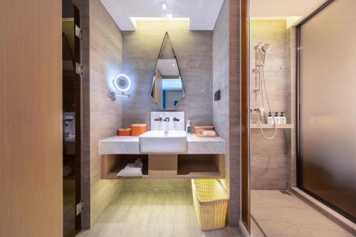 a bathroom with a sink and a mirror at Atour Hotel Kunming Municipal Government Chunrong Street in Kunming