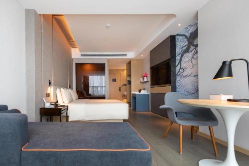 Habitación de hotel con cama y mesa en Atour Hotel Shenzhen Fuhai International Convention and Exhibition Center en Bao'an