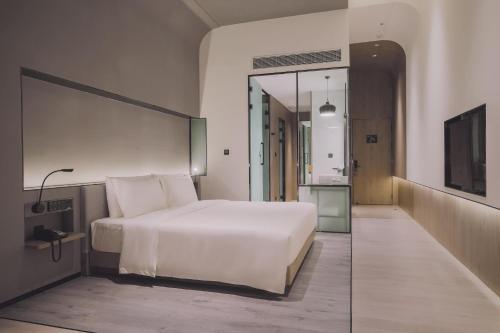 a bedroom with a large white bed and a mirror at Atour S Hotel Shanghai Hongqiao Center Aegean-Late night Congee in Shanghai