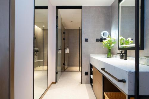 a bathroom with a sink and a shower at Atour Hotel Shenyang Zhongshan Plaza in Shenyang