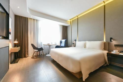 a hotel room with a large bed and a table at Atour Hotel Beijing Wangjing 798 Art District in Beijing