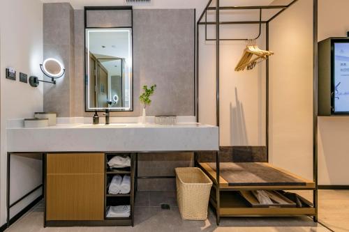 ein Bad mit einem Waschbecken und einem Spiegel in der Unterkunft Atour Hotel Quanzhou Hongchang Baozhou Road in Quanzhou