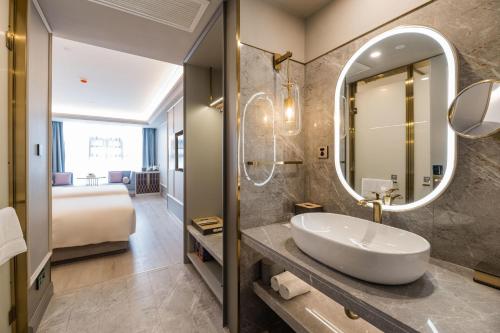 uma casa de banho com um lavatório e um espelho grande em Atour Hotel Chengdu Kuanzhai Alley em Chengdu