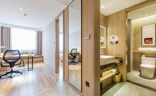 a bathroom with a sink and a toilet and a desk at Atour Hotel Shanghai Hongqiao National Exhibition Center Wuzhong Road in Shanghai